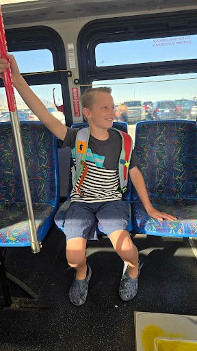 Makai, the son of Olympic medalist, Noelle Pikus Pace, smiling with excitement as he rides in the airport shuttle